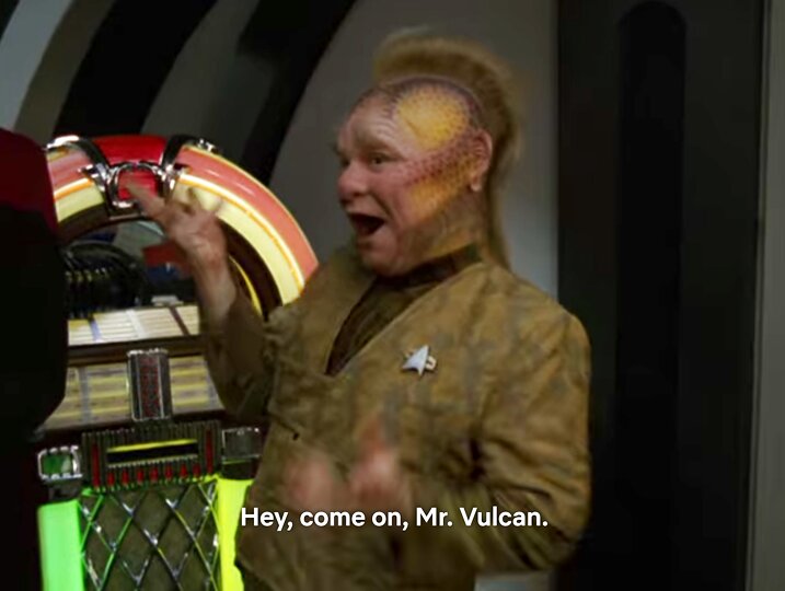 Neelix posiert fröhlich vor einer Jukebox aus dem 20 Jh. und sagt: Hey, come on, Mr. Vulcan.