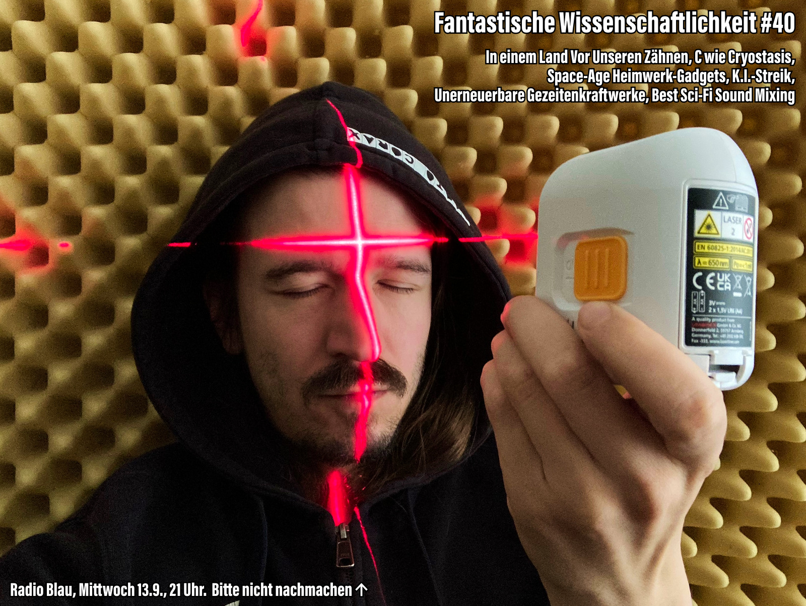 Flyer für Fantastische Wissenschaftliche #40. Kuba hat mit geschlossenen Augen ein kleines Gerät auf sich gerichtet, das ein rotes Laserkreuz auf seine Stirn strahlt. Im Hintergrund ein eierkartonförmiger Schallschutz aus Schaum. Text: "In einem Land vor unseren Zähnen, C wie Cryostasis, Space-Age Heimwerk-Gadgets, K.I.-Streik, Unerneuerbare Gezeitenkraftwerke, Best Sci-Fi Sound Mixing. Radio Blau, Mittwoch 13.9., 21 Uhr. Bitte nicht nachmachen (Pfeil auf das, was Kuba da macht).